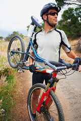 Ready to take on the trail. Shot of a sportsman carrying his mountain bike.