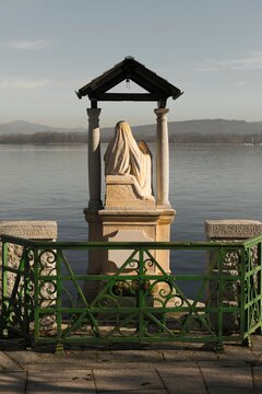 Madonna Statue on the Waterfront on Alpine Lake Maggiore in a Sunny Day in Arona, Piedmont in Italy.