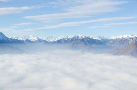 Aerial View over Snow-capped Mountain Above Cloudscape in a Sunny Day in Locarno, Switzerland.