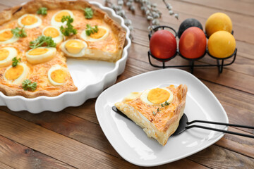 Plate with piece of tasty Easter tart with eggs on wooden background