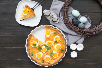 Composition with tasty Easter tart, painted eggs and wreath on dark wooden background