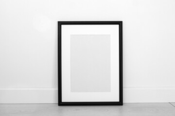 One minimalist black frame mockup on white background in interior