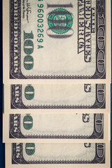 Vertical photo of several packs of hundred-dollar bills close-up of flatlay. Several hundred-dollar...