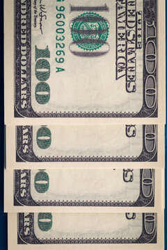 Vertical photo of several packs of hundred-dollar bills close-up of flatlay. Several hundred-dollar bills.