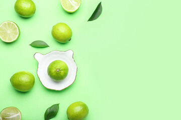 Ceramic juicer and limes on green background