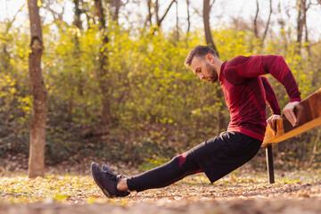 Man doing dips while working out in street workout park