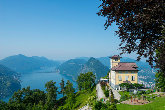 Panoramic View over Alpine Lake Lugano and Mountain with a House on Monte Bre in Ticino, Switzerland.