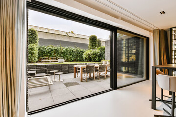 Attractive huge sliding glass door leading to the courtyard - obrazy, fototapety, plakaty