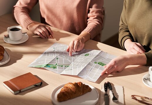 Two Women Looking at a Mockup Map in a Caf&eacute;