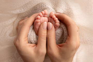 Mother is doing massage on her baby foot. Closeup baby feet in mother hands. Prevention of flat...