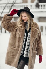 Smiling young woman hat coat outside flowers bouquet yellow joy gift blonde model