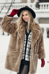 Smiling young woman hat coat outside flowers bouquet yellow joy gift blonde model
