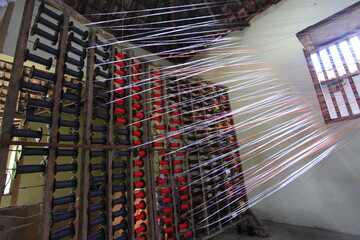 Colorful string used for traditional lurik weaving in a garment factory producing lurik fabric. 