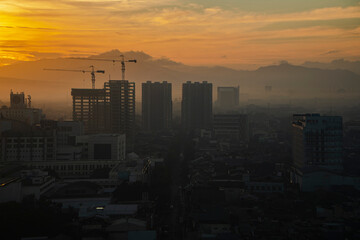 Foggy city view in the morning with beautiful sun shining in Bandung, Indonesia