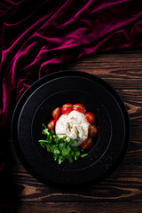 Salad with traditional italian burrata cheese with arugula and tomatoes