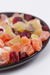 Close up of dried fruits in a black cup.