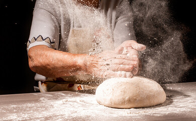 Bread in the old wrinkled hands of the grandmother close-up. Grandmas bread dough. Grandmother...