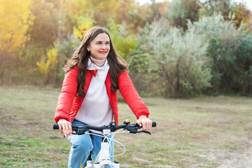 Naklejka premium Portrait of a happy smiling woman riding a bicycle on the outdoor. Active sporty people concept image