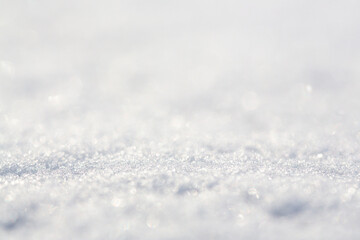 White snow close-up. Winter background with snow texture. Shallow depth of field and blur. Perfect for Christmas and New Year design. View with copy space.