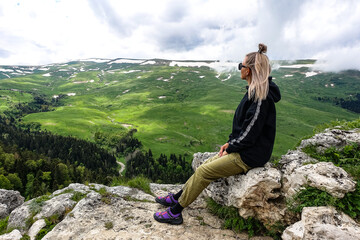 A girl on the background of alpine meadows of the Lago-Naki plateau in Adygea. Russia. 2021.