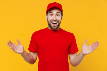 Fototapeta premium Professional delivery guy employee surprised man in red cap blank print design T-shirt uniform workwear work as dealer courier spread hands isolated on plain yellow background studio. Service concept.