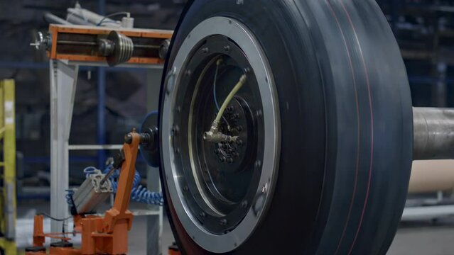 Tyre production machine rotating with new car rubber tire at industrial factory