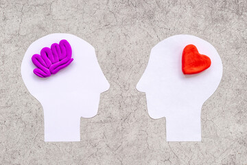 Brain and heart - logic and emotion. Communication between two paper human heads - obrazy, fototapety, plakaty