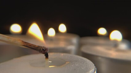 Close-up view of lighting candles. Macro view of lighting several candles using a match.