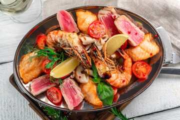 Mixed seafood grilled Shrimp, Squid, Salmon, Tuna and vegetables. Grilled sea assorted fish and shrimp on a platter