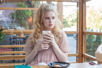 Beautiful female model woman drinking coffee in a italian cafe