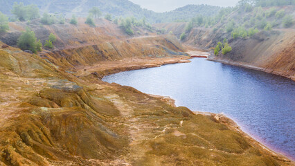 Shore of toxic red lake in open pit of abandoned copper mine near Sia, Cyprus