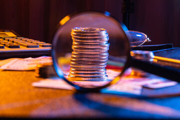 A stack of iron money. View of a small change through a magnifying glass. Pocket money under a...
