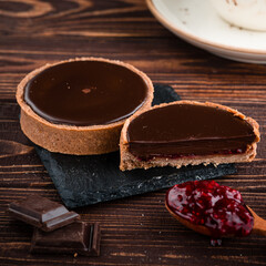 round tartlet in butter cream, baked tartlet dessert, chocolate tartlet with berry