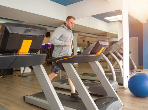 guy jogging on a treadmill in the gym. Fitness, workout and healthy lifestyle