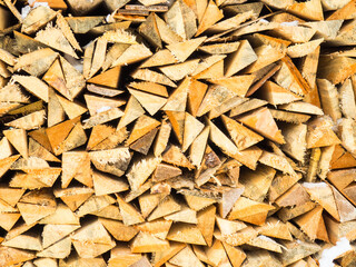 firewood natural background. Quarters of firewood are stacked in a pile, a background of firewo