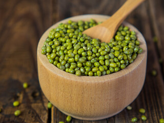raw green mung beans in a bowl on an old wooden table. leguminous plant for a healthy diet