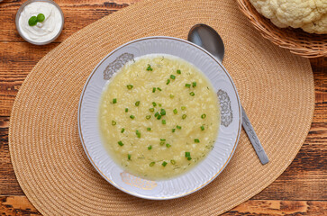 creamy cauliflower soup with green onions view from above