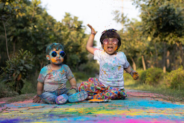 Happy Asian Indian Kids Boy And Girl Enjoying The Festival Of Colors With Holi Color Powder Called...