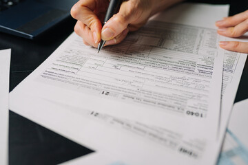 Woman filling US tax form 1040. tax form us business income office hand fill concept. Closeup