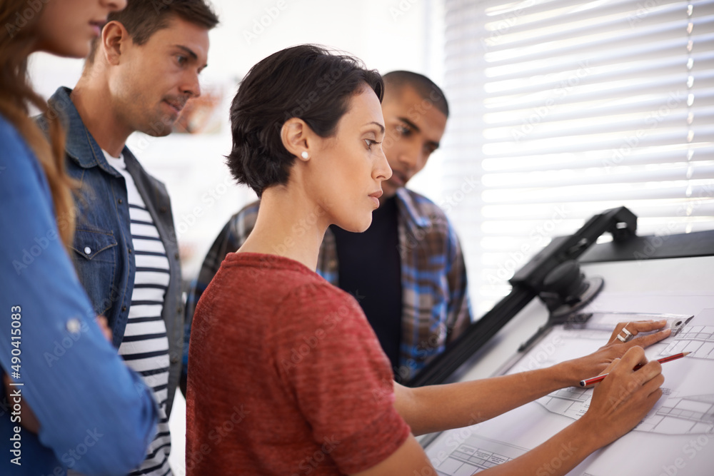 Poster showing the students how its done. shot of a group of young designers working together in an office.