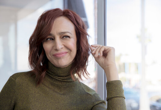 A middle-aged woman with red hair facing the camera and looking off frame.