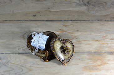 A white casket with gold is placed in a casket resembling a heart.