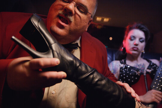Dominatrix putting boot in man's face