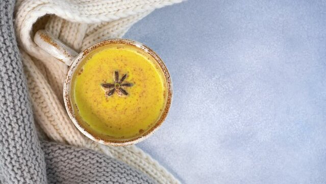 Star anise is spinning in a glass of turmeric golden moon milk. Healthy drink.