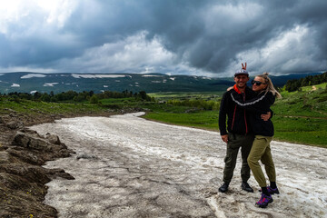 Obraz premium A girl with a man on a glacier on the snowy plateau of Lagonaki in Adygea. Russia. 2021.