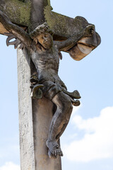 Jesus Christ on the cross old antique stone sculpture covered in moss, cemetery graveyard figure object closeup detail, nobody. Christianity, catholicism, christian and catholic symbols concept