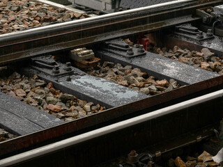 Railroad track detail, closeup, water on train tracks up close, old metal rails, railway in heavy rain. Sadness, melancholy, gloomy day abstract concept, nobody, no people