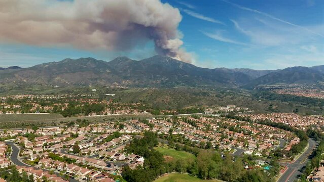 A panning aerial view of a fire in the Santa Ana Mountains from Mission Viejo, California
