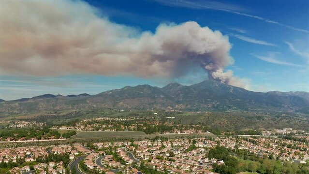 Approaching aerial view of a fire in the Santa Ana Mountains from Mission Viejo, California