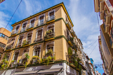 Fototapeta na wymiar original historic building with balconies and potted plants in Alicante Spain